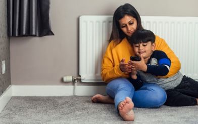 Mum And Son Sit By A Radiator