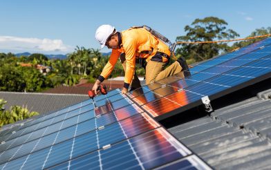 Worker installing solar panels on a roof